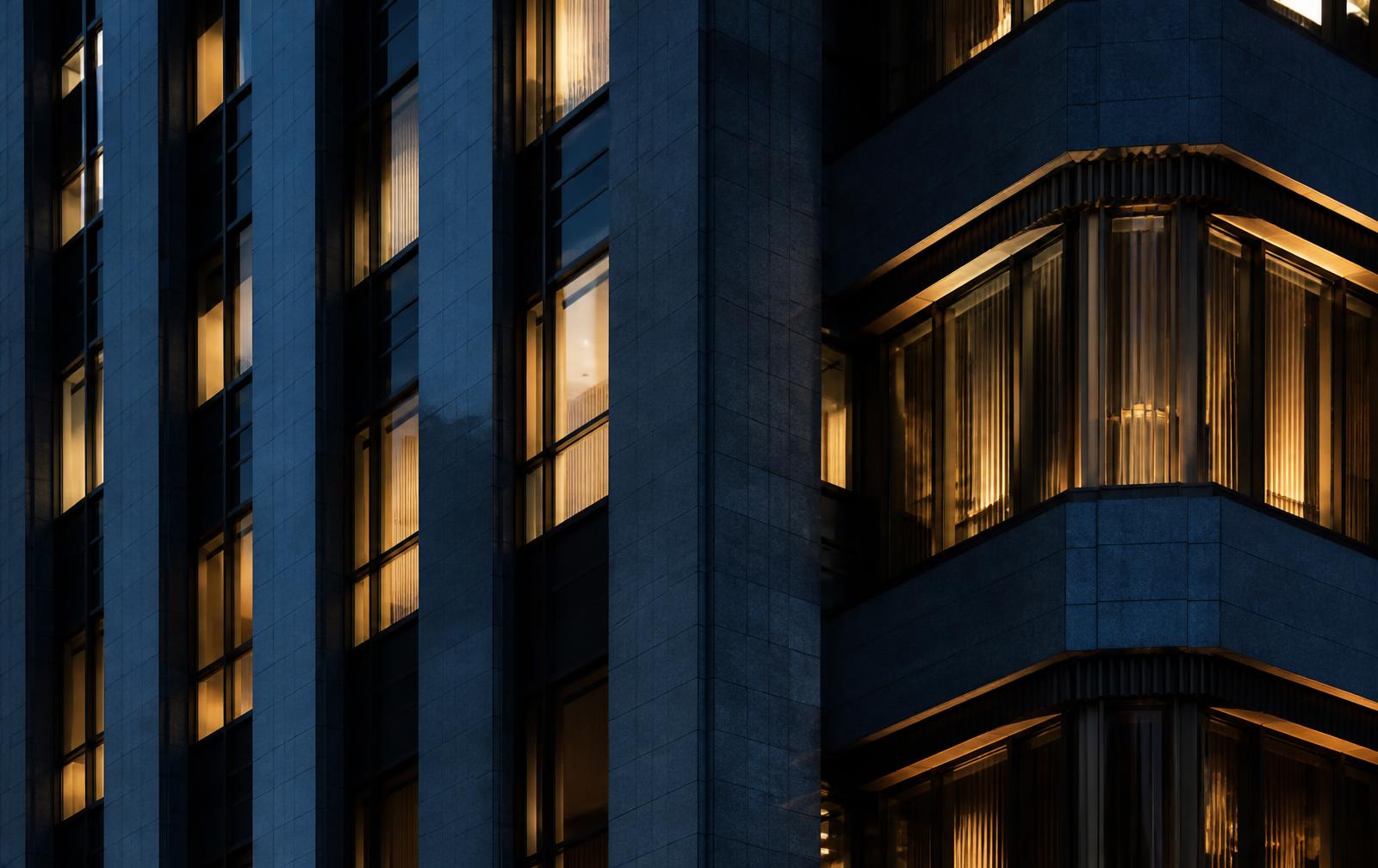 Architectural facade at blue hour with warm interior light in the windows